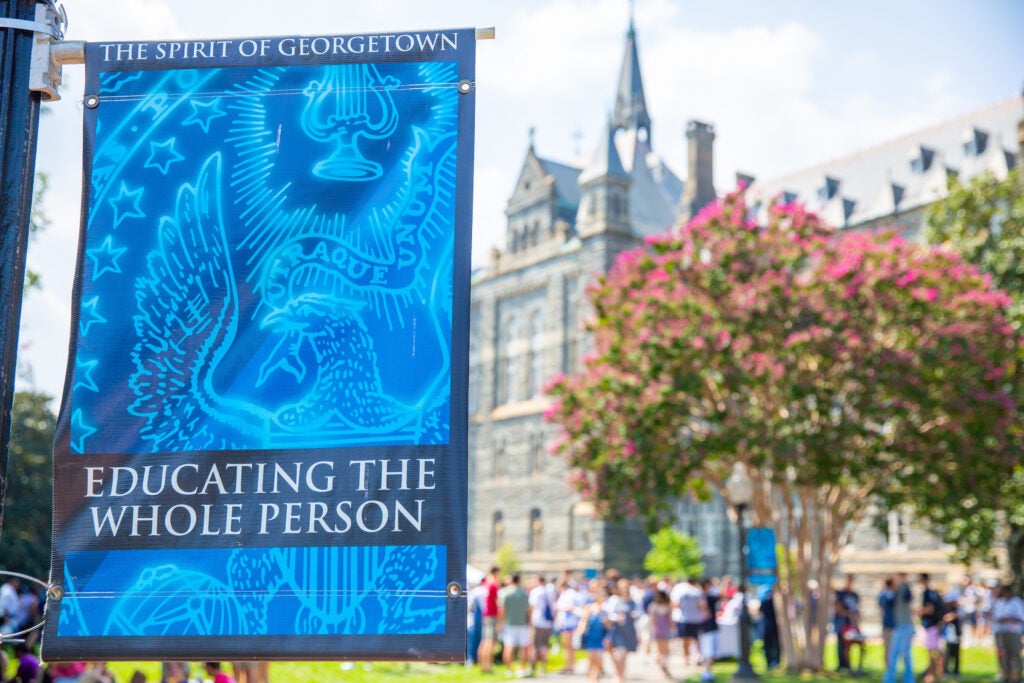 Banner with "The Spirit of Georgetown: Educating the Whole Person" saying & image of White Gravenor hall is the background